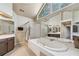 Bright bathroom with tub, tile surround, shower and oversized windows at 220 Galesburg Dr, Lawrenceville, GA 30044