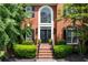 Inviting brick entryway with double doors, lush greenery, and elegant black accents at 220 Galesburg Dr, Lawrenceville, GA 30044