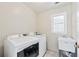 Laundry room with washer, dryer, utility sink and window at 220 Galesburg Dr, Lawrenceville, GA 30044