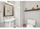 Powder room featuring pedestal sink, modern lighting, and rustic wood accents at 220 Galesburg Dr, Lawrenceville, GA 30044