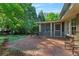 Outdoor patio with brick pavers, surrounded by lush greenery and a screened porch at 4261 Brookview Se Dr, Atlanta, GA 30339