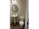 Half bathroom featuring a pedestal sink, round mirror, and modern toilet at 6423 Rosetta Drive, Unit 66 # 66, South Fulton, GA 30331