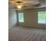 Spacious bedroom featuring plush carpet, a ceiling fan, and two windows at 6423 Rosetta Drive, Unit 66 # 66, South Fulton, GA 30331
