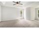 Spacious bedroom boasts a ceiling fan and tray ceiling, with natural light filtering in through the windows at 712 Brambling Way, Stockbridge, GA 30281