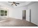 Airy bedroom with a ceiling fan, window views, and doorway looking into other rooms of the house at 712 Brambling Way, Stockbridge, GA 30281