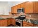 Well-appointed kitchen with wooden cabinets, stainless steel appliances, granite counters, and tile backsplash at 712 Brambling Way, Stockbridge, GA 30281