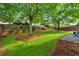 Manicured backyard with lush green grass, mature trees, and a wooden fence at 813 Poplar Ter, Canton, GA 30115