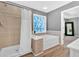 Bright bathroom featuring a separate tub and shower with a patterned window and modern finishes at 813 Poplar Ter, Canton, GA 30115