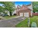Two-story brick home with attached two-car garage, green lawn, and a long driveway at 813 Poplar Ter, Canton, GA 30115