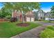 Two-story brick home with attached garage, green lawn, mature trees, and sidewalk in a residential area at 813 Poplar Ter, Canton, GA 30115