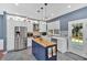 Well-lit kitchen with white cabinetry, stainless steel appliances, a blue island, and stone countertops at 813 Poplar Ter, Canton, GA 30115