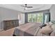 Comfortable main bedroom with large windows, neutral tones, tray ceilings, and carpeting at 813 Poplar Ter, Canton, GA 30115
