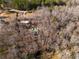 Drone shot showing a log cabin home nestled amongst trees, outbuildings and long driveway at 1225 Pitts Chapel, Newborn, GA 30056