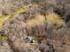 Drone shot showing a log cabin home nestled amongst trees and a large grass field at 1225 Pitts Chapel, Newborn, GA 30056