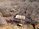 An aerial view shows a log cabin home nestled amongst trees and various outbuildings and driveways at 1225 Pitts Chapel, Newborn, GA 30056