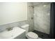 Modern bathroom with gray tile shower, vanity, toilet and dark shower curtain at 1225 Pitts Chapel, Newborn, GA 30056