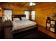 A rustic bedroom featuring hardwood floors, exposed beams, and a dark wood bedframe at 1225 Pitts Chapel, Newborn, GA 30056