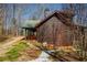 Side view of log home with a covered porch, showing its wood siding and natural setting at 1225 Pitts Chapel, Newborn, GA 30056