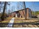 Metal storage building with a pedestrian door, concrete path, propane tank, and metal siding at 1225 Pitts Chapel, Newborn, GA 30056
