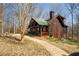 Charming log cabin with a green roof, inviting front porch, and a landscaped front yard at 1225 Pitts Chapel, Newborn, GA 30056