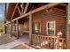 Covered log cabin porch showcasing rustic wood finishes, ample seating, and tranquil outdoor views at 1225 Pitts Chapel, Newborn, GA 30056