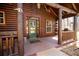 Inviting front porch with log beams, green door, and cozy seating area at 1225 Pitts Chapel, Newborn, GA 30056