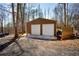 Metal garage exterior with two roll-up doors, concrete pad, and gravel driveway at 1225 Pitts Chapel, Newborn, GA 30056