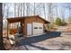 Exterior view of the detached garage with a covered carport and gravel driveway at 1225 Pitts Chapel, Newborn, GA 30056