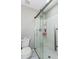 A clean bathroom featuring a glass door walk-in shower and toilet at 1570 Shire Village Dr, Sugar Hill, GA 30518