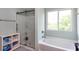 Bright bathroom with a glass-enclosed shower, a soaking tub under a window, and linen storage at 1570 Shire Village Dr, Sugar Hill, GA 30518