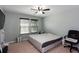 Bedroom with ceiling fan, large bed, and sun-filled double windows at 1570 Shire Village Dr, Sugar Hill, GA 30518
