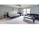 Spacious bedroom features a ceiling fan, large bed, sitting area, and plenty of natural light through the windows at 1570 Shire Village Dr, Sugar Hill, GA 30518