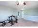Bright bonus room featuring neutral carpeting, ceiling fan, and exercise equipment at 1570 Shire Village Dr, Sugar Hill, GA 30518