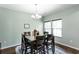 Inviting dining area featuring a modern chandelier, sleek table set, and warm, neutral tones at 1570 Shire Village Dr, Sugar Hill, GA 30518