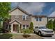 Charming brick townhome showcasing a well-manicured front yard and neutral color palette at 1570 Shire Village Dr, Sugar Hill, GA 30518
