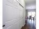 Hallway leading to the dining room with white closet doors and wood floors at 1570 Shire Village Dr, Sugar Hill, GA 30518