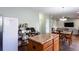 Open kitchen flows into dining area, features a center island and wood floors at 1570 Shire Village Dr, Sugar Hill, GA 30518