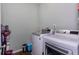 Laundry room features newer washer and dryer on matching wood-look flooring at 1570 Shire Village Dr, Sugar Hill, GA 30518