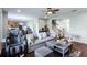 Living area with wood floors, sofa, chair, and open views of the kitchen and stairs at 1570 Shire Village Dr, Sugar Hill, GA 30518