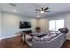 A spacious living room with wood floors, plush seating, and a large window for natural light at 1570 Shire Village Dr, Sugar Hill, GA 30518