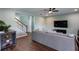 Comfortable living room features wood floors, stairs, and a large sofa and TV at 1570 Shire Village Dr, Sugar Hill, GA 30518