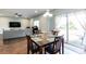 Open concept living space with dining room table, couch and outdoor access at 1570 Shire Village Dr, Sugar Hill, GA 30518