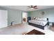 A bright main bedroom suite with a ceiling fan, bed, sitting area, and ensuite bathroom at 1570 Shire Village Dr, Sugar Hill, GA 30518