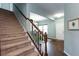 Interior shot showcasing the carpeted staircase with a view to the front door and dining area at 1570 Shire Village Dr, Sugar Hill, GA 30518