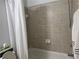 Cozy bathroom featuring neutral colored tiles and a shower-tub combo at 2107 Hailston Dr, Duluth, GA 30097