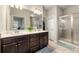 Bathroom featuring double sinks, dark wood cabinetry, and a tiled shower at 2170 Trelipe Dr, Lawrenceville, GA 30044