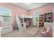 Cheerful pink bedroom with a loft bed, desk, and shelving at 2170 Trelipe Dr, Lawrenceville, GA 30044