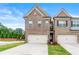 Two-story brick townhome featuring a two-car garage and a well-manicured front yard at 2170 Trelipe Dr, Lawrenceville, GA 30044