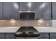 Close up of a kitchen featuring gray cabinets, stainless steel appliances, and a gas cooktop at 1393 Halpern Nw Ln, Kennesaw, GA 30144