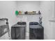 Well-lit laundry room with modern washer, dryer and storage shelf at 1393 Halpern Nw Ln, Kennesaw, GA 30144